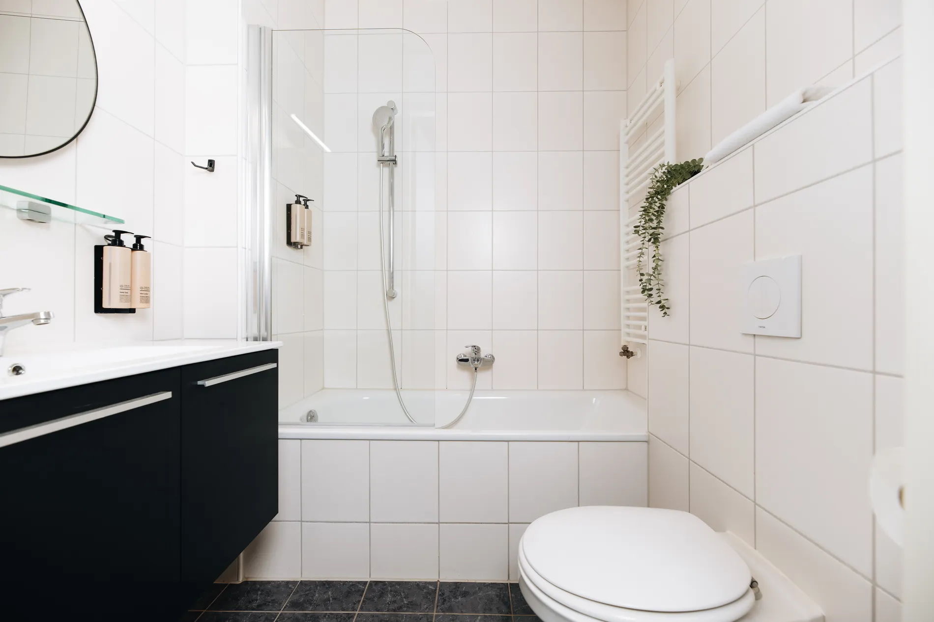 Ruime, lichte badkamer bij Resort Land & Zee voorzien van een ligbad met douchewand, toilet en modern wastafelmeubel.